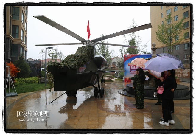 小區(qū)突然出現(xiàn)“飛機坦克”，其中殲15艦載戰(zhàn)斗機一架、99式主戰(zhàn)坦克一輛、武直-10武裝直升機一架，吸引了眾多市民雨中圍觀、合影。